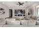 Spacious living room with a ceiling fan, built-in shelving, and comfortable seating at 16373 W Beautiful Ln, Goodyear, AZ 85338