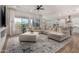 Open-concept living room with a sectional sofa, large windows and elegant decor at 16373 W Beautiful Ln, Goodyear, AZ 85338