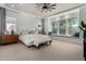 Serene bedroom with large windows, a cozy window seat, carpet flooring and neutral decor at 16373 W Beautiful Ln, Goodyear, AZ 85338
