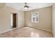 Neutral bedroom featuring tile floors, a window, ceiling fan, and access to an adjacent room at 1749 W Monterosa St, Phoenix, AZ 85015