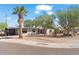 Charming single story home featuring desert landscaping, mature trees, and a red front door at 1749 W Monterosa St, Phoenix, AZ 85015