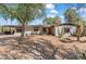 Inviting single story home with desert landscaping, mature trees, and a vibrant red front door at 1749 W Monterosa St, Phoenix, AZ 85015
