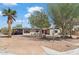 Quaint single story home featuring desert landscaping, mature trees, and solar panels at 1749 W Monterosa St, Phoenix, AZ 85015