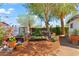 A spacious garden featuring planters, garden boxes, mulch beds, mature trees, and greenery at 1749 W Monterosa St, Phoenix, AZ 85015