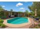 Backyard showcasing a private pool with blue tiling, a seating area, and lush landscaping at 1749 W Monterosa St, Phoenix, AZ 85015