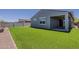 Well-maintained backyard featuring artificial grass, a covered patio, and block wall fencing at 17704 W Fetlock Trl, Surprise, AZ 85387