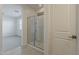 En suite bathroom featuring tile flooring, glass shower, and white door at 17704 W Fetlock Trl, Surprise, AZ 85387