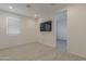 Bright bedroom features wood-look flooring, a wall-mounted TV, and a window for natural light at 17704 W Fetlock Trl, Surprise, AZ 85387
