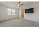Bedroom features carpet, ceiling fan, natural light and a TV at 17704 W Fetlock Trl, Surprise, AZ 85387