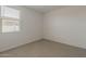 Bright bedroom featuring neutral carpeting, large window, and white walls at 17704 W Fetlock Trl, Surprise, AZ 85387