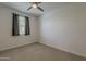 Neutral bedroom featuring carpet, large window, and dark curtain panels at 17704 W Fetlock Trl, Surprise, AZ 85387