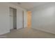 This bedroom boasts neutral carpeting, a closet, and an open doorway to a bright room at 17704 W Fetlock Trl, Surprise, AZ 85387