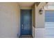 Stylish blue front door with modern hardware and a decorative light fixture at 17704 W Fetlock Trl, Surprise, AZ 85387