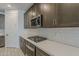 Contemporary kitchen featuring white subway tile backsplash, stainless steel appliances, and dark cabinetry at 17704 W Fetlock Trl, Surprise, AZ 85387