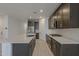 Modern kitchen featuring an island with sink, stainless steel appliances, and dark wood cabinetry at 17704 W Fetlock Trl, Surprise, AZ 85387