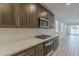 The kitchen features stainless steel appliances, sleek cabinets, and a subway tile backsplash at 17704 W Fetlock Trl, Surprise, AZ 85387