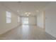 Light-filled living area with wood-look tile flooring, neutral walls, and a sliding glass door at 17704 W Fetlock Trl, Surprise, AZ 85387