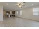 The open-concept living area features a ceiling fan, wood-look tile flooring, and recessed lighting at 17704 W Fetlock Trl, Surprise, AZ 85387