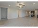 Spacious living area with light-colored walls, wood-look tile flooring, and modern recessed lighting at 17704 W Fetlock Trl, Surprise, AZ 85387