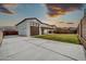 Exterior view of the home and backyard with lush lawn and block fence at 19026 W Becker Ln, Surprise, AZ 85388