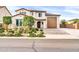 Charming home with meticulously landscaped front yard, brick driveway, and covered front porch at 19026 W Becker Ln, Surprise, AZ 85388