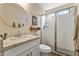 Bright bathroom featuring a glass-enclosed shower and a granite vanity with a round mirror at 19039 N 47Th Ave, Glendale, AZ 85308