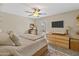 Cozy bedroom featuring a ceiling fan, TV, dresser, and door to the backyard at 19039 N 47Th Ave, Glendale, AZ 85308