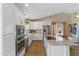 Bright kitchen with white cabinets, a stainless steel refrigerator, and an island with stone countertops at 19039 N 47Th Ave, Glendale, AZ 85308