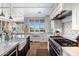 Bright kitchen featuring farmhouse sink, white cabinetry, marble countertops, and stainless steel appliances at 19296 N 98Th Pl, Scottsdale, AZ 85255