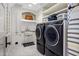 Bright laundry room with modern washer and dryer, farmhouse sink, and ample storage at 19296 N 98Th Pl, Scottsdale, AZ 85255