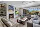Inviting living room featuring a fireplace, comfortable seating, and seamless indoor-outdoor flow to the backyard at 19296 N 98Th Pl, Scottsdale, AZ 85255