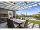 Outdoor dining area with a white pergola, large table, and a view of the pool at 19296 N 98Th Pl, Scottsdale, AZ 85255