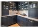 Elegant pantry featuring custom navy cabinets, marble countertops and backsplash, with glass door storage at 19296 N 98Th Pl, Scottsdale, AZ 85255