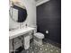 Modern powder room with designer wallpaper, patterned floors, pedestal sink, and a round decorative mirror at 19296 N 98Th Pl, Scottsdale, AZ 85255