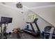 Workout room featuring a treadmill, Peloton bike, weights and dark wood floor at 19296 N 98Th Pl, Scottsdale, AZ 85255