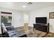 Bright living room with wood-look flooring, a modern TV, and a comfortable sofa that provides plenty of seating at 195 N Cottonwood St # 26, Chandler, AZ 85225