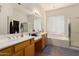 Bathroom with double sinks, a soaking tub, and a glass-enclosed shower at 1955 E Grand Canyon Dr, Chandler, AZ 85249