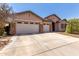 Lovely home exterior featuring a three-car garage, stone accents and a welcoming entrance at 1955 E Grand Canyon Dr, Chandler, AZ 85249