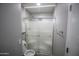 Bathroom featuring a frosted glass door shower, toilet, and cabinet with shelving above the toilet at 20221 N 31St St, Phoenix, AZ 85050
