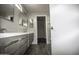 Bathroom with modern double vanity, gray cabinets, two large mirrors, and vinyl floors at 20221 N 31St St, Phoenix, AZ 85050