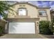 Two story home with a white garage door, desert landscaping, and a beige exterior paint at 20221 N 31St St, Phoenix, AZ 85050
