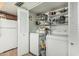 Laundry room with washer, dryer, fridge, and storage shelves filled with household items at 2041 W Pierson St, Phoenix, AZ 85015