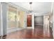 Bright living room with sliding glass doors to patio, stylish light fixture, and beautiful hardwood floors at 2134 E Broadway Rd # 1062, Tempe, AZ 85282