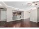Open-concept living room with sleek hardwood floors, a ceiling fan, and a partial view of the kitchen at 2134 E Broadway Rd # 1062, Tempe, AZ 85282