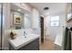 Well-lit bathroom with a modern vanity, textured wall tiles, and a separate shower and tub at 2201 N Central Ave # 3C, Phoenix, AZ 85004