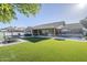 Spacious backyard with well-maintained artificial grass, patio seating, an outdoor grill, and a covered patio area at 22709 S 202Nd St, Queen Creek, AZ 85142