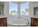 Corner soaking tub with custom faucet fixtures, surrounded by windows offering bright, natural light at 22709 S 202Nd St, Queen Creek, AZ 85142