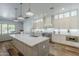 Bright kitchen with quartz countertops, stainless appliances, and a large island with pendant lighting at 22709 S 202Nd St, Queen Creek, AZ 85142