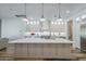 A spacious kitchen features a large center island with pendant lighting and sleek white cabinetry at 22709 S 202Nd St, Queen Creek, AZ 85142
