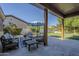 Covered patio area featuring comfortable outdoor seating and a view of the lush, green backyard at 22709 S 202Nd St, Queen Creek, AZ 85142